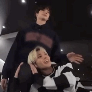 a man is carrying another man on his shoulders while they are standing next to each other .