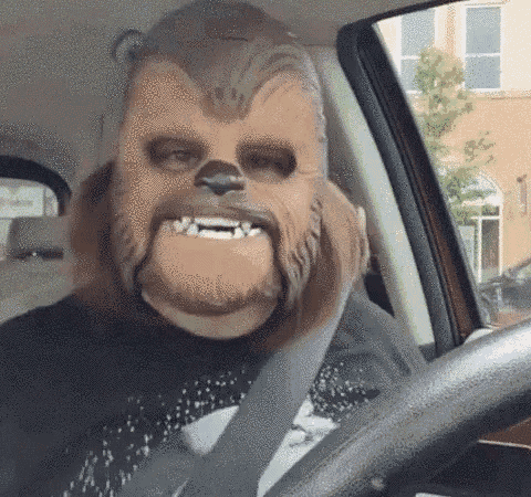a man is wearing a chewbacca mask and driving a car .