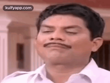 a man with a mustache is making a funny face .