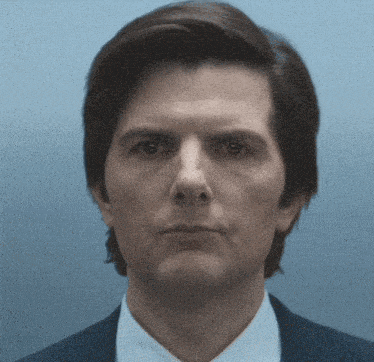 a close up of a man 's face in a suit and tie