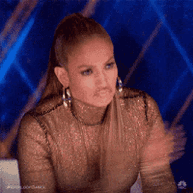 A woman claps while seated at a panel table.