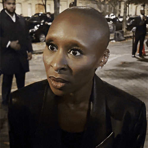 Cynthia Erivo looks to the side with a shocked, wide-eyed expression.