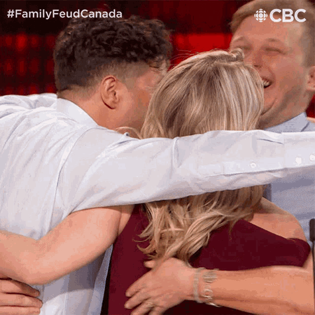 a group of people hugging each other with a cbc logo in the background