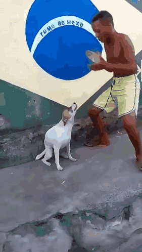 A person dances beside a dog outdoors near a mural.