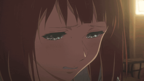 An anime woman cries quietly in warm indoor light.