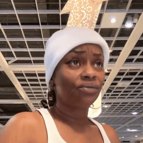 A woman in a white hat gives a unimpressed sideways look in a store.