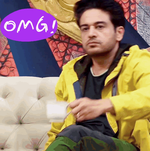 a man in a yellow jacket is sitting on a couch with a purple omg sticker above him