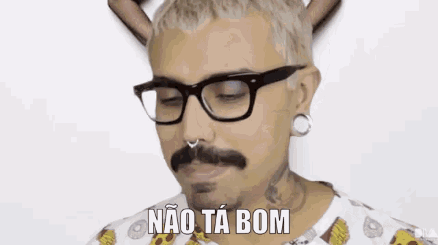 a man wearing glasses and a nose ring says não ta bom
