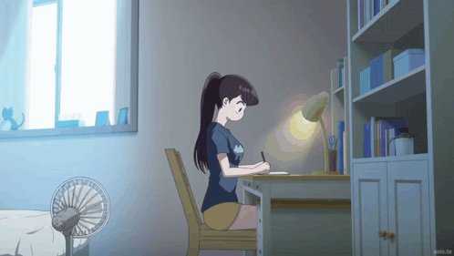 An anime girl sits sleepily at a desk in a softly lit room.