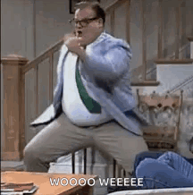 A man in a suit dances wildly across a room with “WOOO YEEEEE”.