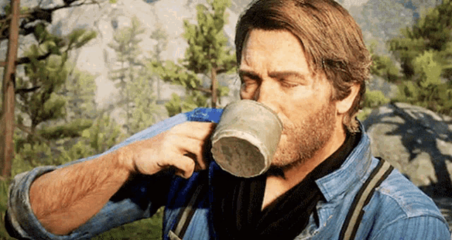 a man with a beard is drinking from a cup in the woods