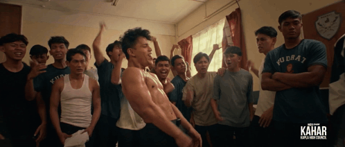 a group of young men are standing in a room with the word kahar on the bottom right