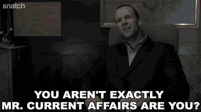a man in a suit sits in a chair and says you aren 't exactly mr