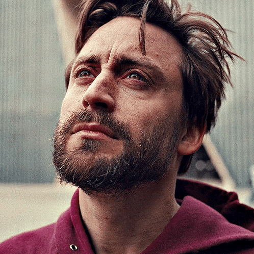 Kieran Culkin looks upward pensively in a scene from A Real Pain.