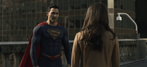 a man in a superman costume hugs a woman