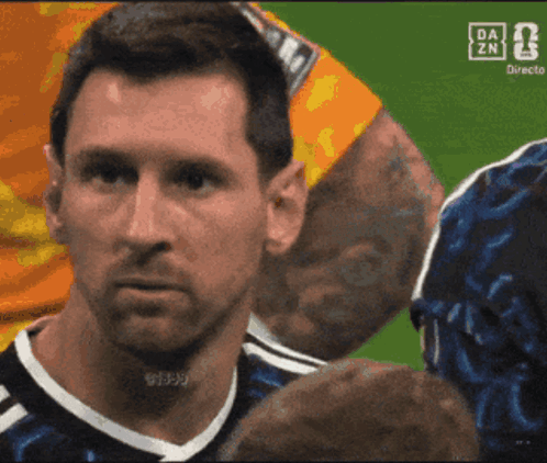 A soccer player in an Argentina jersey looks tense and emotional.
