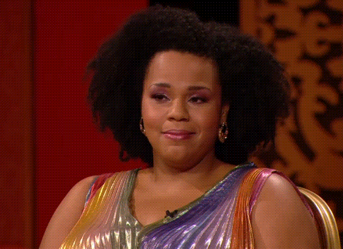 Desiree Burch smiles with a resigned, knowing expression on Taskmaster.