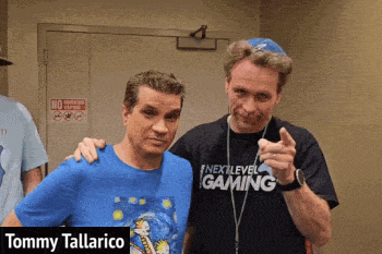 two men are posing for a picture and one of them is wearing a next level gaming shirt