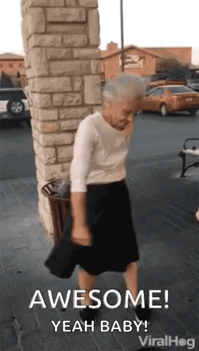 An elderly woman dances outside near a stone building, captioned “AWESOME!”