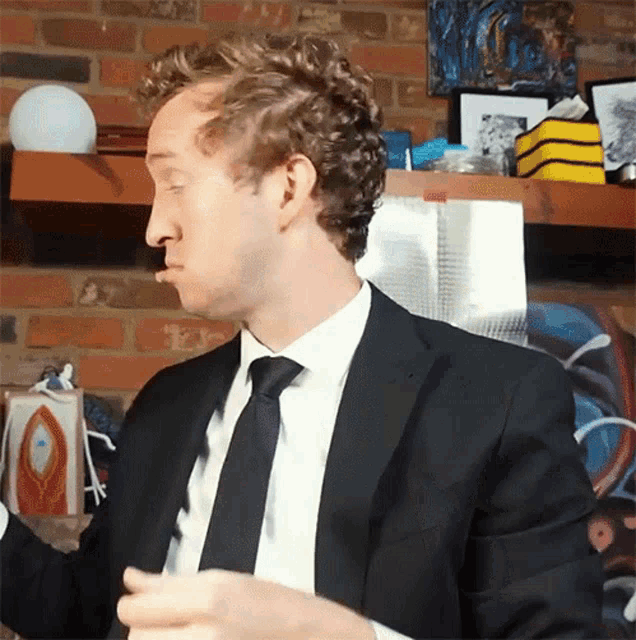 a man in a suit and tie is making a face
