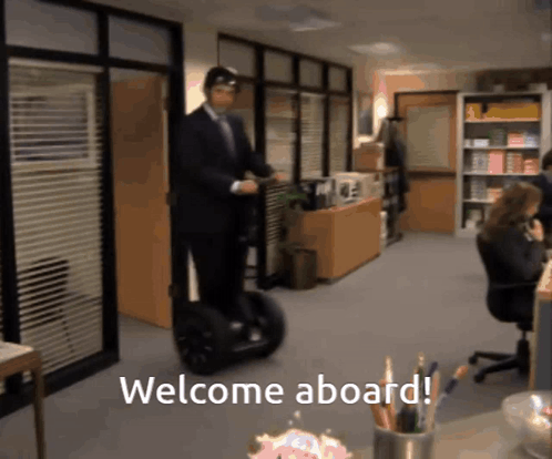 a man riding a segway in an office with the words welcome aboard