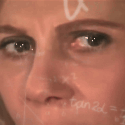 a close up of a woman 's face in front of a chalkboard with x1 written on it