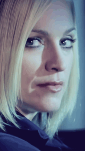 a close up of a woman 's face with a blue shirt on