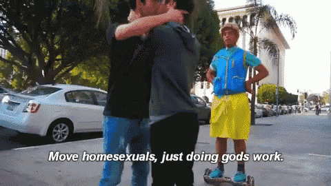a man on a scooter says " move homosexuals just doing gods work " while hugging another man