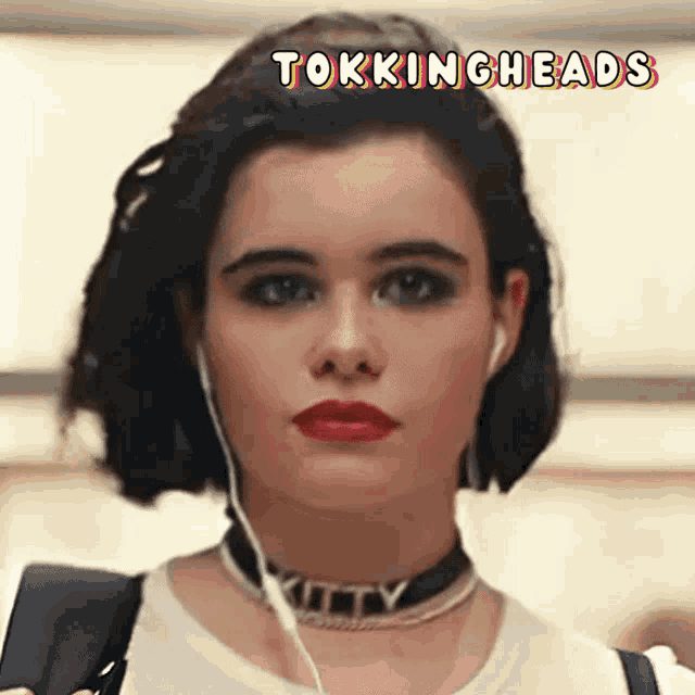 a woman wearing ear buds and a choker with the word kitty on it