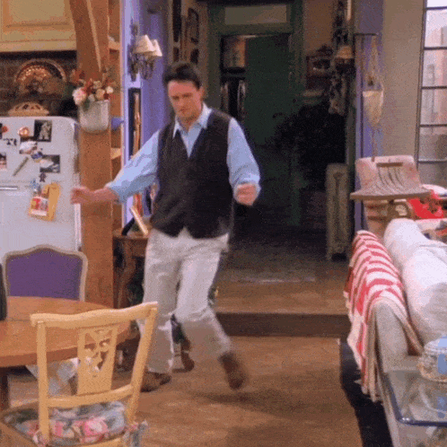 A man dances through a living room in a scene from Friends.