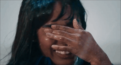 a woman covering her face with her hand in the water