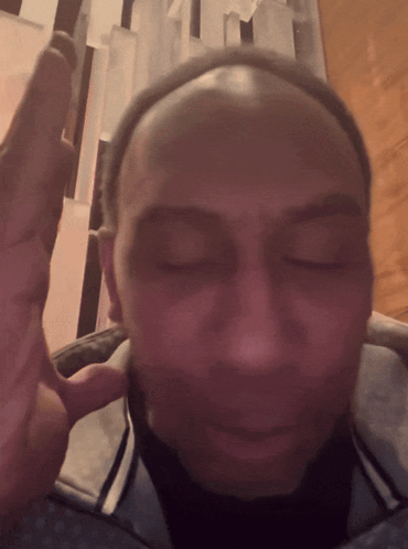 A man rubs his face while looking downward in a stressed reaction.