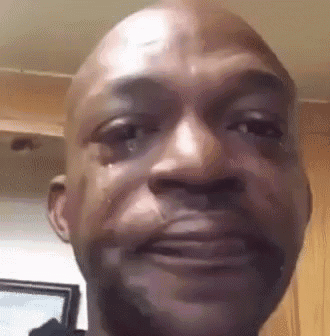 A man looks forward with tears streaming down his face.