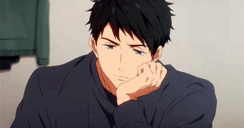 An anime boy rests his cheek on his hand, looking bored and sleepy.