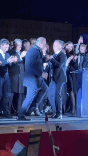 a man in a suit is dancing with another man