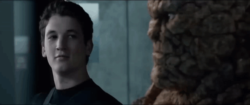 a young man in a black shirt stands in front of a statue