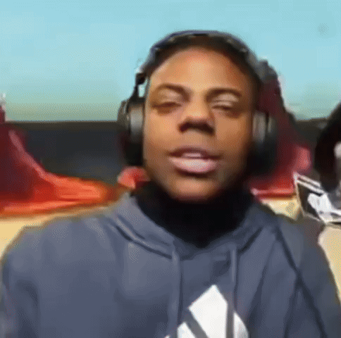 a man wearing headphones and a blue hoodie looks at the camera