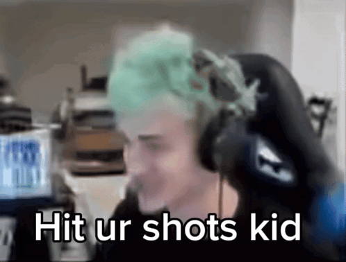 a man with green hair is wearing headphones and has the words hit ur shots kid written on his face .