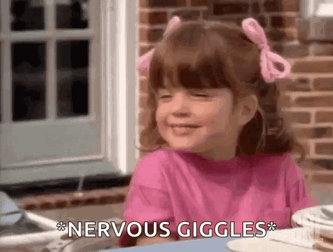 A little girl giggles at a table as the subtitle says “*NERVOUS GIGGLES*.”