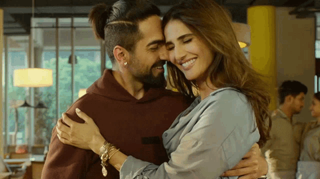 a man and a woman are hugging and smiling