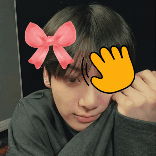 A man with a bow graphic and waving-hand sticker pats his head.