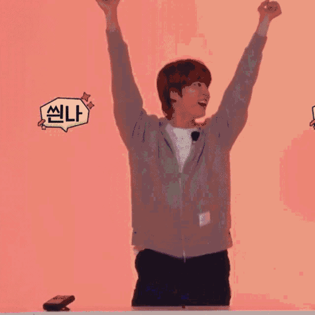 a man with his arms in the air is standing in front of a purple wall .