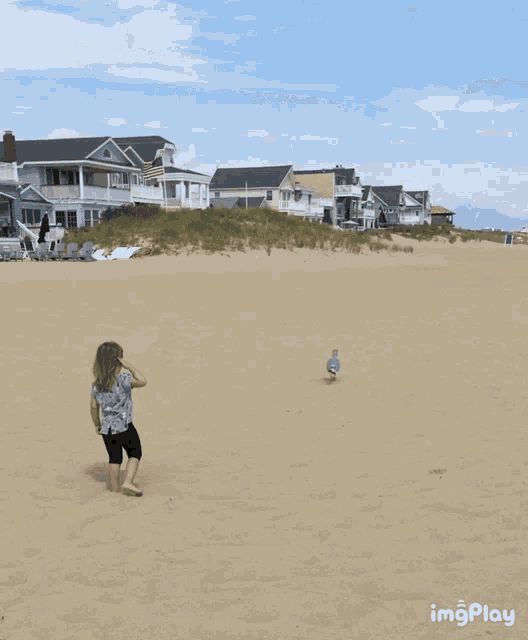 a little girl running on a sandy beach with houses in the background and the words imgplay below her