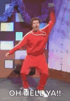 A dancer in red performs onstage with “OH HELL YEA!!”