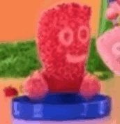 a stuffed animal made of gummy bears is sitting on a blue container .
