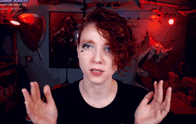 a woman with red hair looks at the camera in front of a screen that says ' zanbaby ' on it
