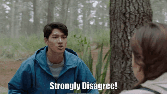 a man in a blue jacket says strongly disagree in front of a tree