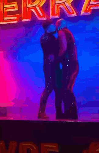 a couple of people standing on a stage with the word erre in the background