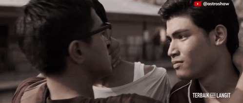 two men are looking at each other in a video that says " terbaik ke langit "