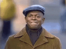 Man in a blue cap claps with a pleased smile.